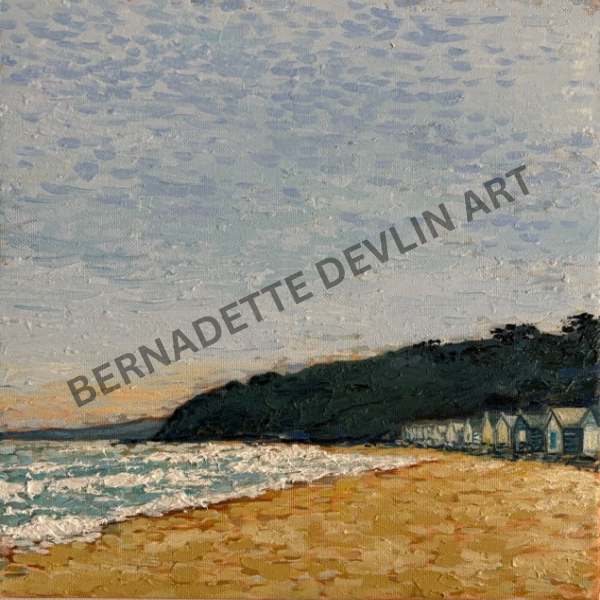 Painting of a beach scene with houses and a cliff, signed 'Bernadette Devlin Art'.